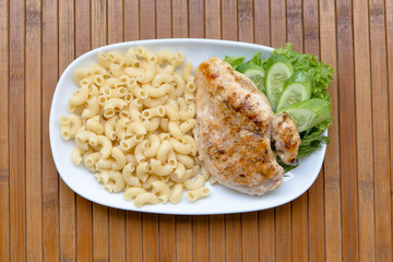 Grilled chicken fillet, pasta and greens