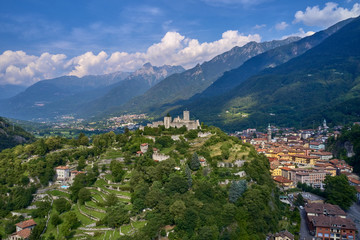 Fototapeta na wymiar Aerial photography, castle of Breno in the province of Brescia, Lombardy region. The castle is located on a mountain surrounded by the Alps in the background the city of Breno in the north of Italy.