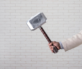 businessman's hand holds hammer Thor
