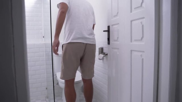 back portrait of man's gesture peeing in a toilet