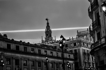 Foto en blanco y negro de un chemtrail (estela química) detrás de la Giralda en Sevilla, España