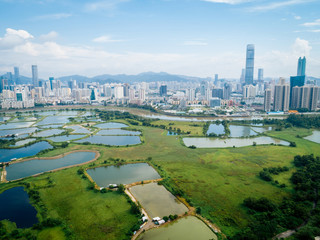 Rural green fields with fish ponds between Hong Kong and skylines of Shenzhen,China