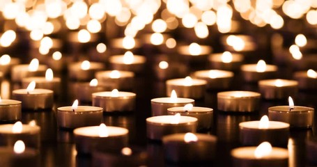 Flickering candles on black granite