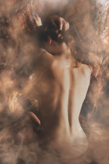 young woman naked back in light brown dreamy smoke