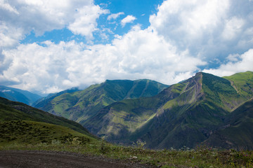 Mountain landscape beautiful green mountains with Alpine lush meadows cloudy sky background