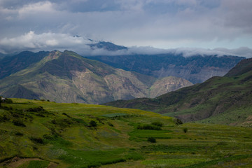 Fototapeta na wymiar Mountain landscape beautiful green mountains with Alpine lush meadows cloudy sky background
