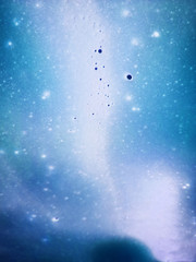 Blue, cyan and white foam with bubbles on the window