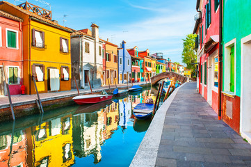 Colorful houses with reflections on the canal in Burano island, Venice, Italy. Famous travel...