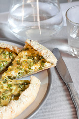 Tart with eggs and green onions on a plate