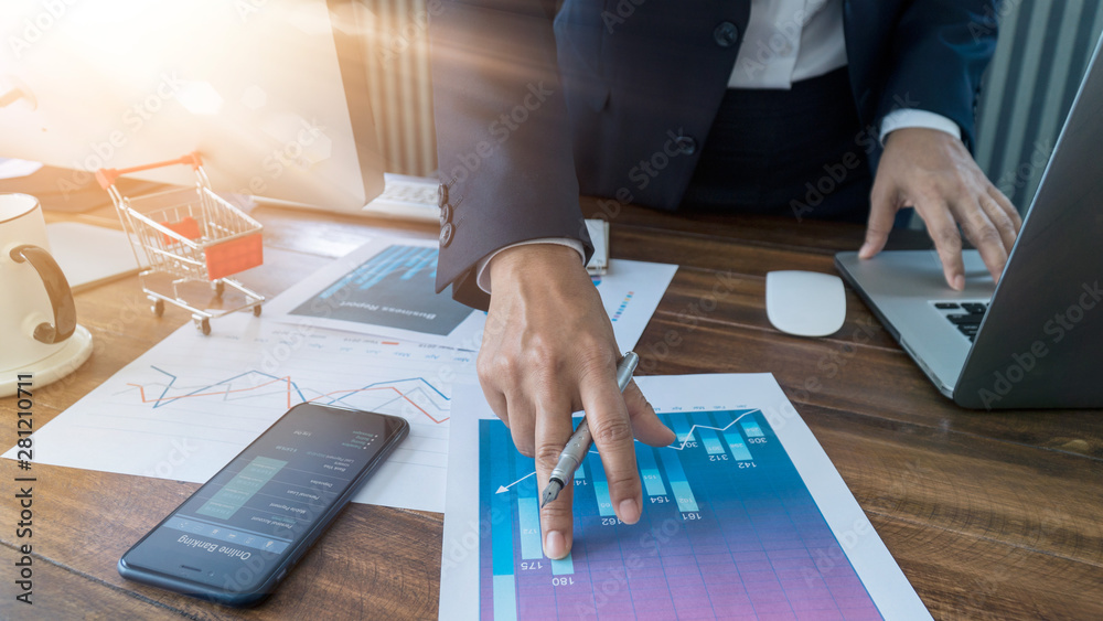 Poster Businessman analyzing sales data and economic growth and    pointing at business report document with graph chart financial diagram, marketing, banking and payments, business planning and strategy.