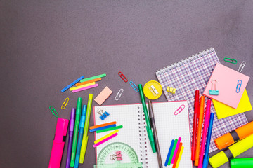 Back to school concept. School education supplies on black stone concrete background.
