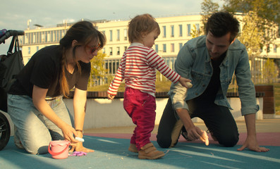 Obraz premium Dad draws with chalks on the playground
