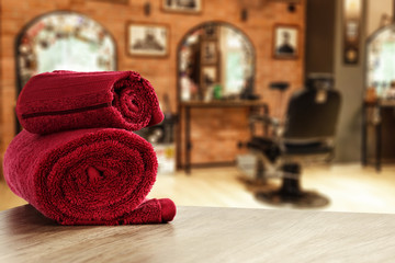 Table background with towels and blurred hairdresser and barber shop view.