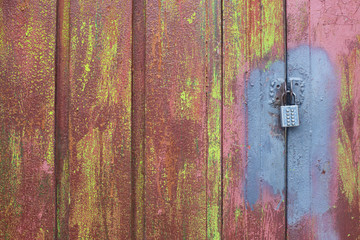 Metal door rusty corroded texture background. cracked color paint with lock.