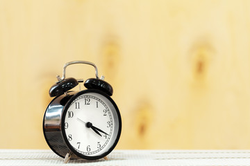 Alarm clock on wooden table close up