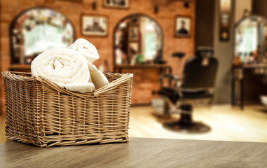 Fototapeta na wymiar Table background with towels and blurred hairdresser and barber shop view.
