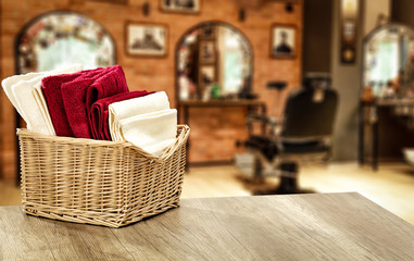Table background with towels and blurred hairdresser and barber shop view.