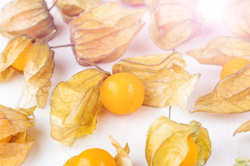 Physalis fruit (Physalis Peruviana) on a white wooden background close-up. Cape Gooseberry.  Minimalism, a place for text.