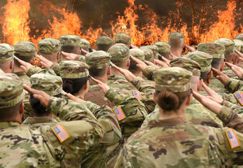 American soldiers saluting and fire in the front (collage)