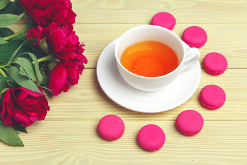 Fototapeta na wymiar Cup of green tea on table with fresh peony flowers