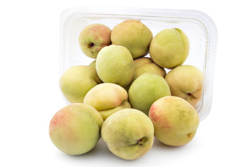 Box or punnet and spilled fresh peaches, Prunus persica, isolated on white background. Vinogradarska breskva. Šeftelija