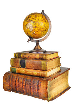 Pile of old used books with ancient globe isolated on white
