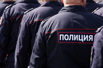 Obraz premium Russian police officers work on a city street. View from the back. Problems of opposition rallies, detentions and arrests