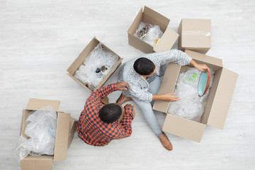 Couple unpacking cardboard boxes in living room