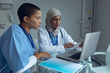 Female doctors using laptop in hospital