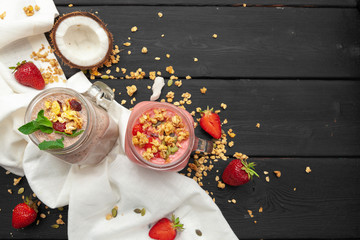 Home-made Yoghurt with granola, fruit and coconut top view on wooden background