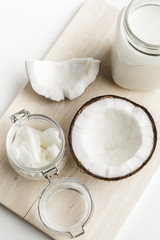 Organic healthy coconut butter and fresh coconut pieces on wooden board