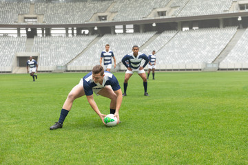 Diverse male rugby players playing rugby match in stadium