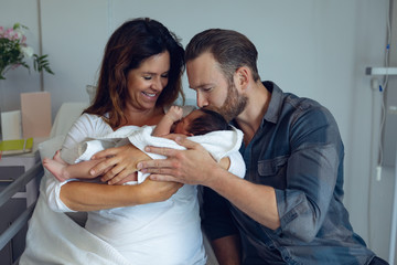 Couple holding their newborn baby in the ward