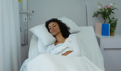 Female patient sleeping on bed in the ward at hospital