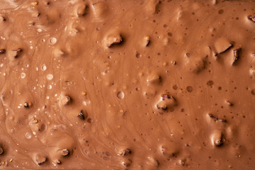 Texture of milk sweet chocolate surface with nuts and dried fruit, macro photo