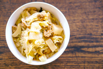 Top view of Mixed boiled vegetables with soy sauce in Chinese style in white ceramic bowl and wooden background. A Vegetarian food in Chinese Vegetarian Festival.