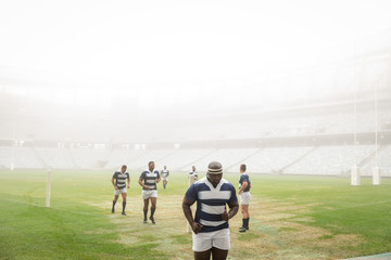 Group of diverse male rugby players running in stadium