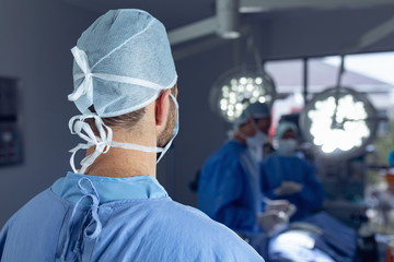 Male surgeon standing in operation room at hospital - obrazy, fototapety, plakaty