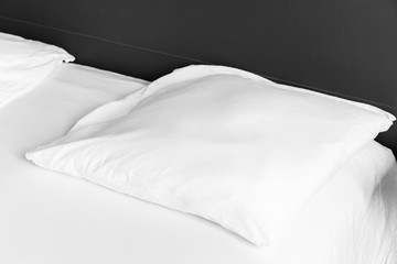 Fototapeta na wymiar White pillow lying on an empty bed