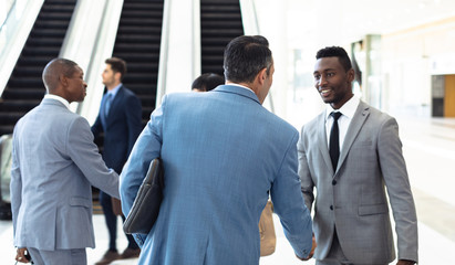 Diverse young executives meeting in front of escalator