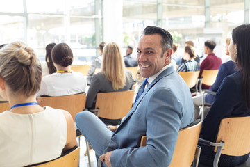 Mature Caucasian male executive sat in conference room, smiling to camera