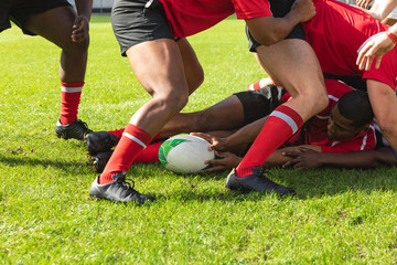 Male rugby players playing rugby match in stadium