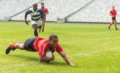 Obraz premium Group of diverse male rugby players playing rugby in stadium