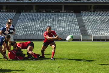 Male rugby players playing rugby match in stadium