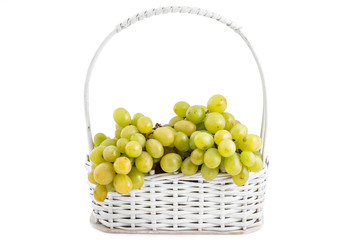Fresh ripe white grapes in white wooden basket isolated on a white