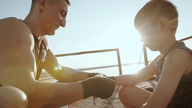 Young Male Boxer Athlete Pulls His Son A Protective Tape