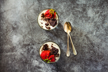 Italian dessert panna cotta decorated with fresh strawberry on a stone or slate background. Top...