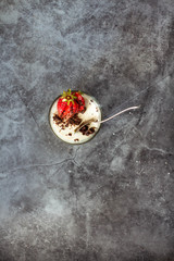 Italian dessert panna cotta decorated with fresh strawberry on a gray  slate background. Top view....