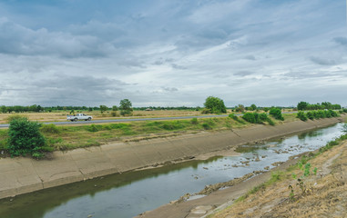 Fototapeta na wymiar Irrigation canal or irrigation channel in concrete wall Send water from the reservoir to the agricultural area of ​​the farmer that is dry in the rainy season of Thailand. 