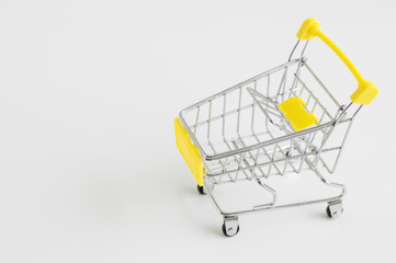 Empty shopping trolley on white background. Shopping cart with yellow plastic elements